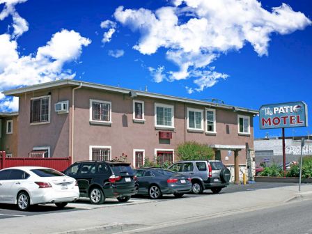 The image shows a two-story motel with a sign reading 